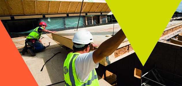 Construction site workers aiding the delivery of off-site timber panels 